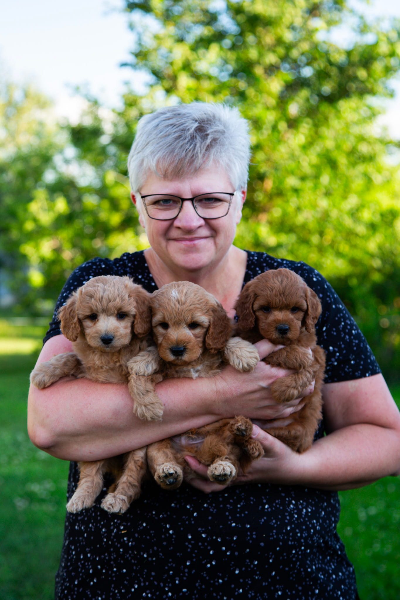 Sonia looking at the camera and holding her tiny puppies