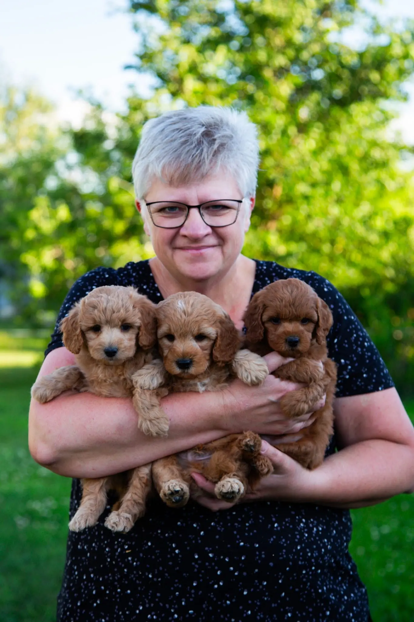 Sonia looking at the camera holding her puppies